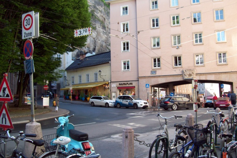 И даже здесь, под аркой, образуемой домом, под проходящей под его этажами улице - ходит троллейбус. <br />Зальцбург (Австрия), днём, 8.05.2014